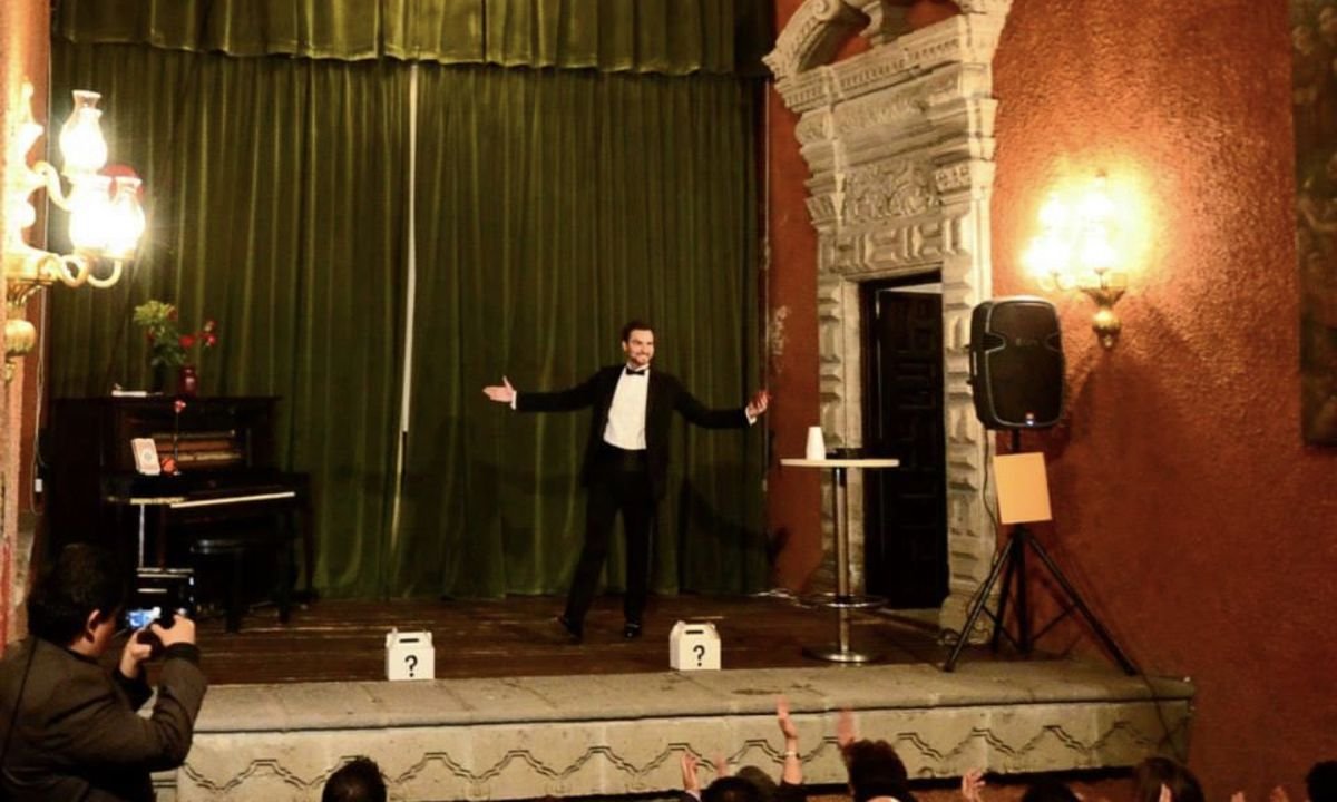 Fernando Mier saludando desde el escenario de un teatro ante el aplauso del público