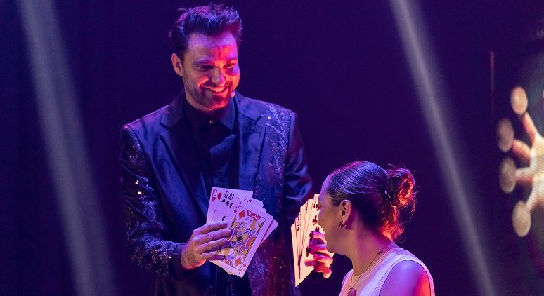 Fernando Mier realizando un juego de cartas junto a una invitada