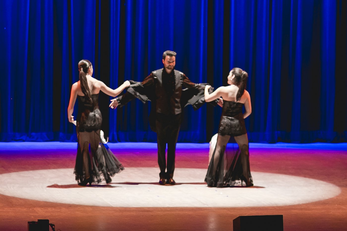 Fernando Mier en el centro del escenario acompañado de dos bailarinas